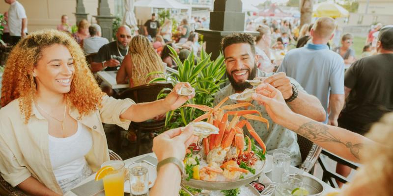 A group of people share a shrimp cocktail at a restaurant in Virginia Beach, Virginia, USA.