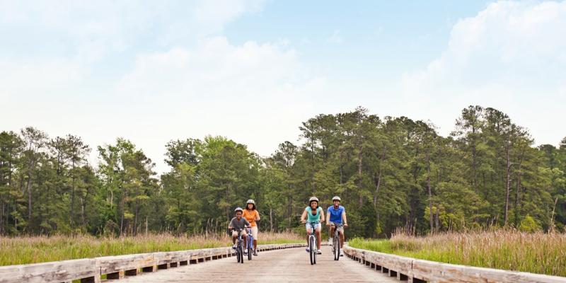 Colonial Parkway A family cycles along the wooden boardwalk road