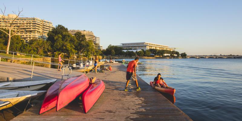 A person helps a kayaker into a red kayak on the waterfront of the Georgetown neighbourhood in Washington, DC