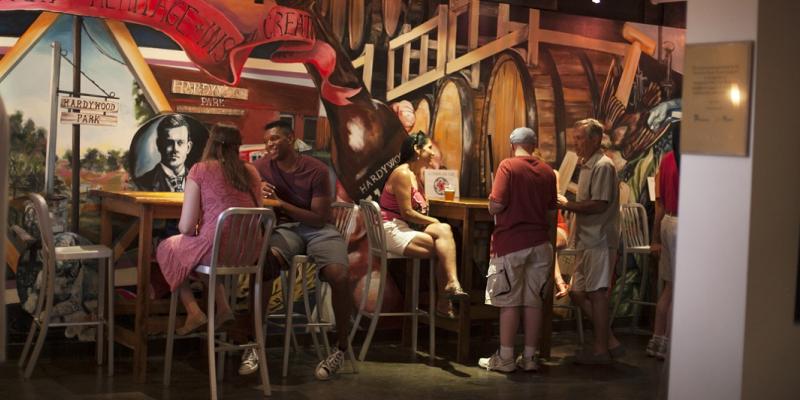 People having drinks in front of mural-painted walls at Hardywood Park Craft Brewery in Richmond, Virginia