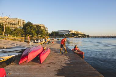 A person helps a kayaker into a red kayak on the waterfront of the Georgetown neighbourhood in Washington, DC