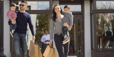 A family with small children walks with shopping bags in the Georgetown neighbourhood of Washington, DC.