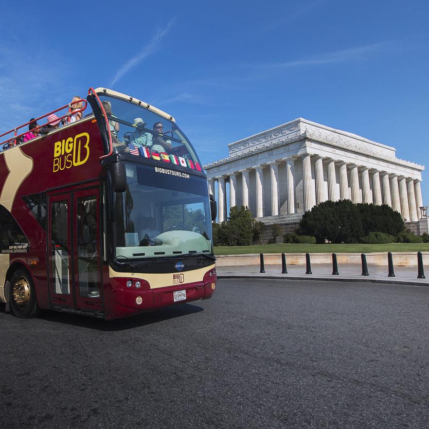 Big Bus with passengers passing the Lincoln Memorial
