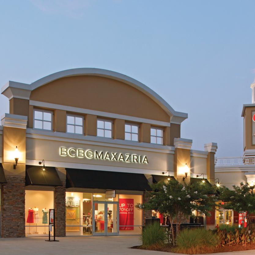 The facade of Queenstown Premium Outlets shopping centre in Queenstown, Maryland, is illuminated at dusk.
