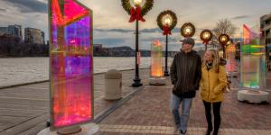 A couple walks along the Potomac River waterfront decorated for the holidays
