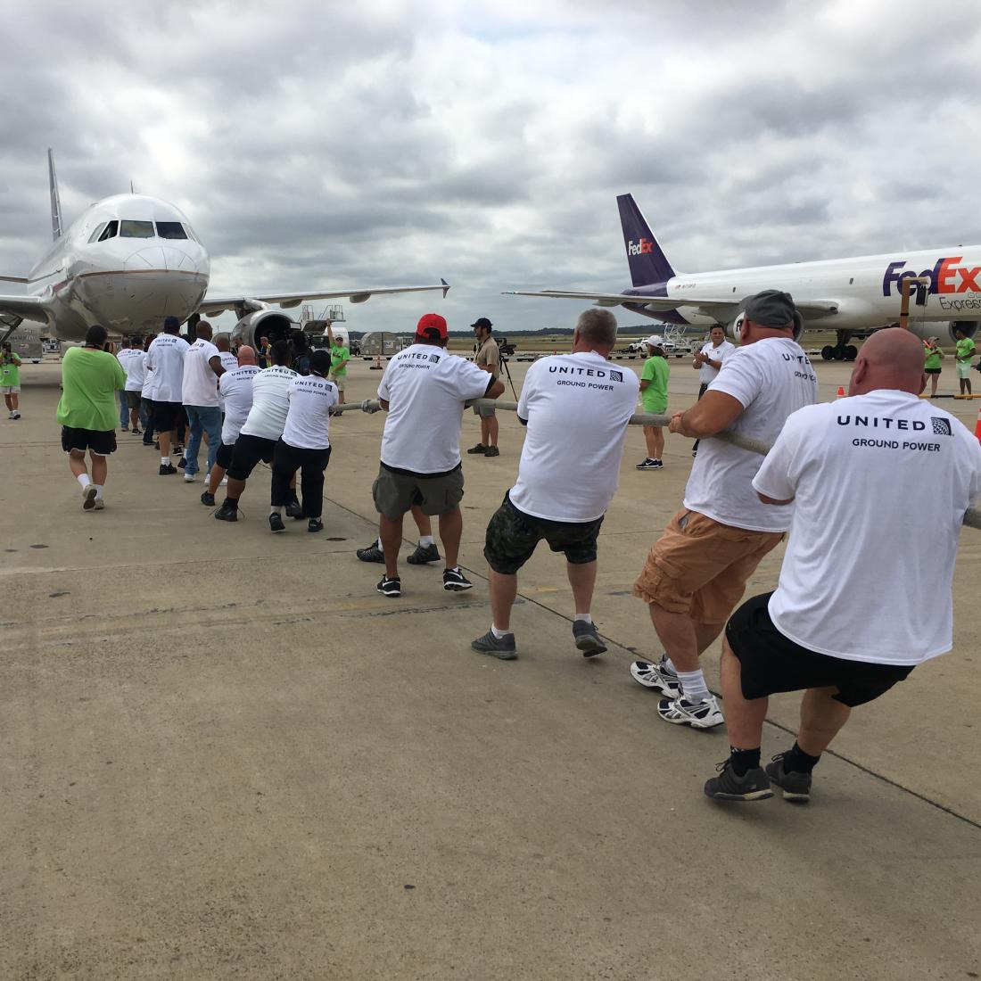 A team of people pull a plane