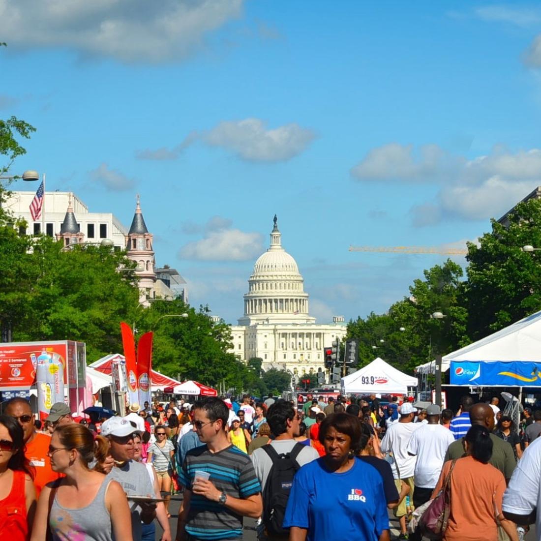 A crowd of festival goers in the street in front of the US Capitol Building